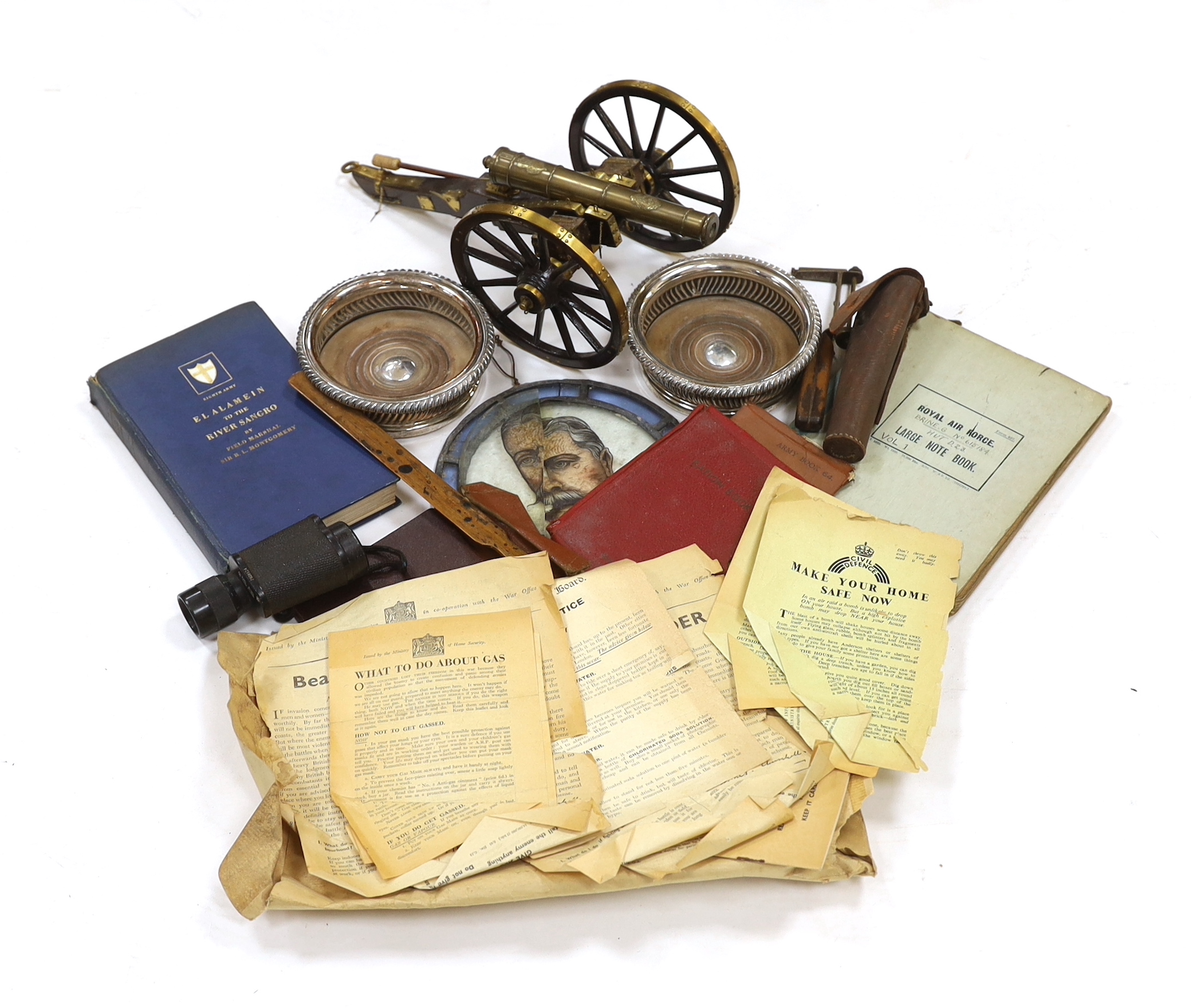 A collection of militaria, including a brass model of a Napoleonic era field gun, a stained glass panel, a Royal Air Force notebook, Civil Defence leaflets, etc.